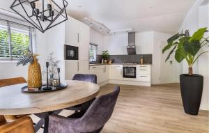 a kitchen and dining room with a wooden table and chairs at 1 Bedroom Stunning Home In Erm in Erm