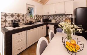 una cocina con armarios blancos y una mesa con fruta. en 3 Bedroom Stunning Home In Zarace, en Zarače