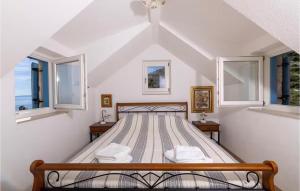 Una cama en una habitación blanca con dos ventanas. en 3 Bedroom Stunning Home In Zarace, en Zarače