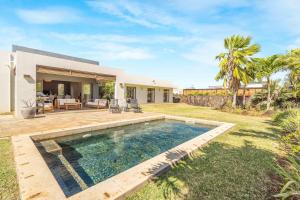 a backyard with a swimming pool and a house at Villa Kygo - Premium Stay by Sealodge Mauritius in Solitude