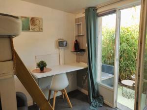 Una pequeña habitación con un escritorio y una ventana. en Evasion maritime plage et port, en Cherbourg-en-Cotentin
