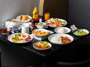 una tavola con piatti e ciotole di cibo di Best Western Ratchada Hotel a Bangkok