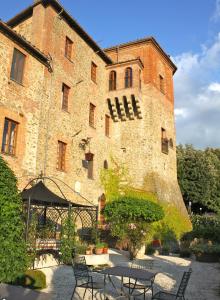 a building with a table and chairs in front of it at Relais Mastro Cinghiale in Paciano