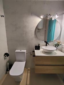 a bathroom with a toilet and a sink and a mirror at Alegre apto con piscina, a 300m de la playa. in Blanes