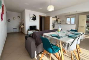 a living room with a table and a couch at MORIANI Centre Lumineux T3 à deux pas de la mer et commerces in Moriani Plage +10 photos