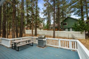 a grill on a deck with a bench and a fence at Bear Woods 3BR Retreat in Big Bear City