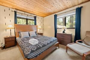 a bedroom with a bed and a chair and windows at Bear Woods 3BR Retreat in Big Bear City