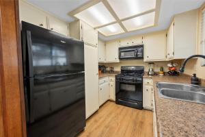 a kitchen with a black refrigerator and a sink at Bear Woods 3BR Retreat in Big Bear City +22 photos