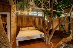een bed in een kamer naast een boom bij Habba Dates Villa Near Chikkaballapur in Bāgepalli +95 foto's