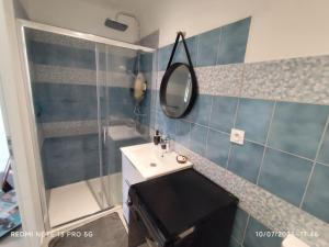 un bagno con lavandino e specchio di La Maison du bonheur a Firminy