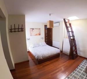 a bedroom with a bed and a ladder in it at Loft con vistas en Plaza de Belén in Jaén