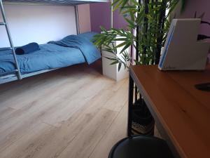 a bedroom with a bed and a desk with a laptop at Le Nid du Haut in Saint-Nectaire