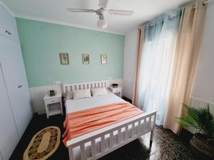 Un dormitorio con una cama y un ventilador de techo. en La Maison du Port, en Puerto Sagunto