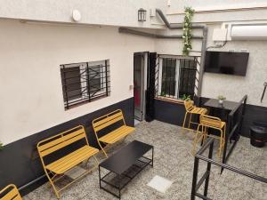 patio con sillas, mesa y TV en La Maison du Port, en Puerto Sagunto