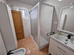 Un baño blanco con ducha y lavabo. en La Maison du Port, en Puerto Sagunto 23 fotos más