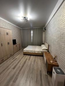 une chambre avec un lit et un mur de briques dans l'établissement Style apartment Bishkek, à Bishkek