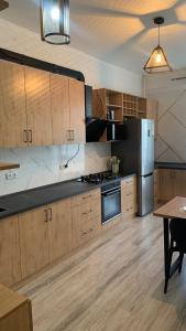 une cuisine avec des armoires en bois et des appareils en acier inoxydable dans l'établissement Style apartment Bishkek, à Bishkek