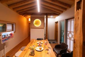 a large wooden table in a room with windows at FeelGood Hanok in Andong