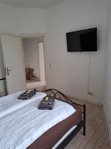 two beds in a room with a tv on the wall at Zimmer am Hauptbahnhof 2 in Minden