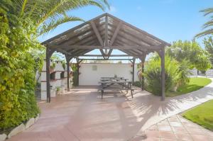 a wooden pergola with a picnic table on a patio at Cartuja Rural in Barbate