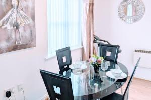 a dining room with a glass table and black chairs at 2 Bed - Sleeps 4 - Free Parking - 5 Min to Centre in Manchester