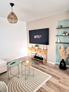 a living room with two chairs and a tv at chez mamy in Reguisheim