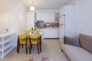 a kitchen with a table and yellow chairs and a couch at Yenier Apart Kas in Kaş +9 photos