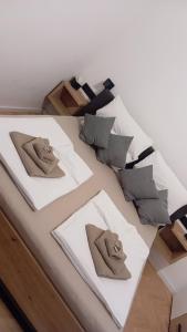 un lit avec trois oreillers dessus dans l'établissement Apartman Leky, à Tuzla
