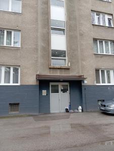 un bâtiment avec une voiture garée devant dans l'établissement Apartman Leky, à Tuzla