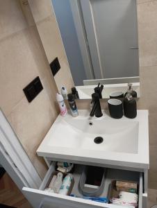 une salle de bain avec un lavabo blanc et un miroir dans l'établissement Apartman Leky, à Tuzla 6 autres photos