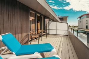 een balkon met blauwe ligstoelen in een gebouw bij Strandhotel Duinoord in Vrouwenpolder