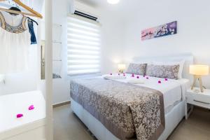 a white bedroom with a bed and a window at Yenier Apart Kas in Kaş