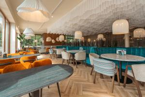 ein Restaurant mit Tischen und Stühlen in einem Raum in der Unterkunft Strandhotel Duinoord in Vrouwenpolder