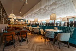 een restaurant met tafels en stoelen en een bar bij Strandhotel Duinoord in Vrouwenpolder +121 foto's