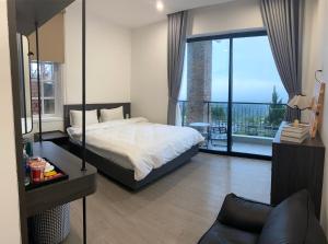 a bedroom with a bed and a large window at Famille Hotel - Central hotel in Dalat in Xuan An +50 photos