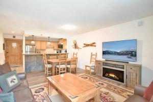 ブリッケンリッジにあるBlazing Saddles High Country Condo - Close To Everythingの暖炉とテレビのあるリビングルーム +9枚の写真
