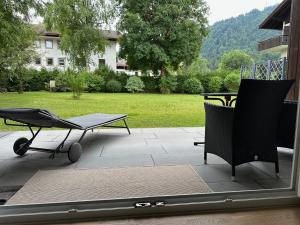 a patio with chairs and a table and a grill at Neues Appartement Helena in Kreuth