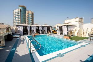 a swimming pool on the roof of a building at Al Khaleej Palace Deira Hotel in Dubai