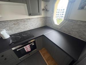 a small kitchen with a stove and a window at Building carré d eden in Clamart