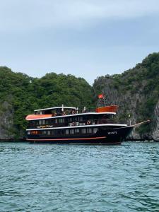 a boat in the water with people on it at Cat Ba Ocean Cruise in Ha Long