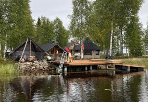a dock in front of a house on a lake at Arctic Private Island - All inclusive HB and activities in Rovaniemi