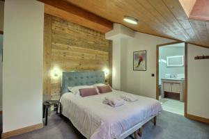 a bedroom with a large bed with a wooden wall at ARC 1950 - Appartement 8 personnes Duplex Cheminée - ski aux pieds - Sauna, Hammam, Jacuzzi, Piscine in Arc 1950 +22 photos