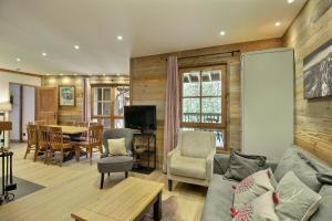 a living room with a couch and a table at ARC 1950 - Appartement 8 personnes Duplex Cheminée - ski aux pieds - Sauna, Hammam, Jacuzzi, Piscine in Arc 1950