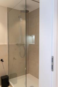 a shower with a glass door in a bathroom at Renovated Munich City Center Apartment near Oktoberfest in Munich