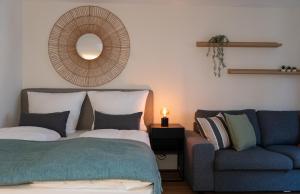 a bedroom with a bed and a couch and a mirror at Renovated Munich City Center Apartment near Oktoberfest in Munich