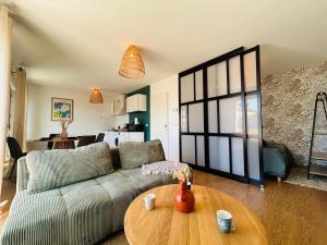 een woonkamer met een bank en een tafel bij Casa Arcade Rougé - Premium - Terrasse - Parking in Cholet