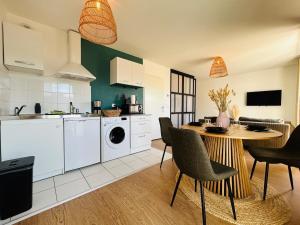 een keuken met een tafel en stoelen in een kamer bij Casa Arcade Rougé - Premium - Terrasse - Parking in Cholet
