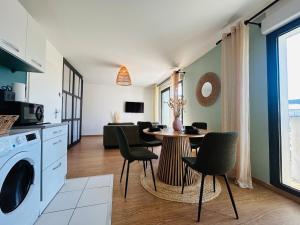 een keuken en woonkamer met een tafel en stoelen bij Casa Arcade Rougé - Premium - Terrasse - Parking in Cholet