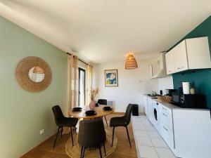 een keuken en eetkamer met een tafel en stoelen bij Casa Arcade Rougé - Premium - Terrasse - Parking in Cholet +12 foto's