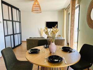 een tafel met stoelen en een vaas met bloemen erop bij Casa Arcade Rougé - Premium - Terrasse - Parking in Cholet